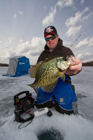 Jason Mitchell holding a panfish while ice fishing. Lure presentation